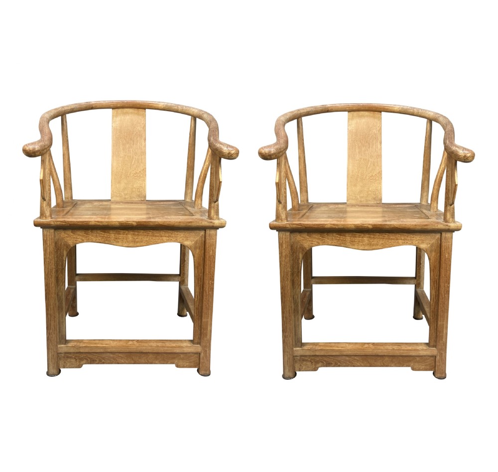 A pair of light brown pickled elm Chinese horseshoe armchairs featuring continuous curved crest rails and central back splats.