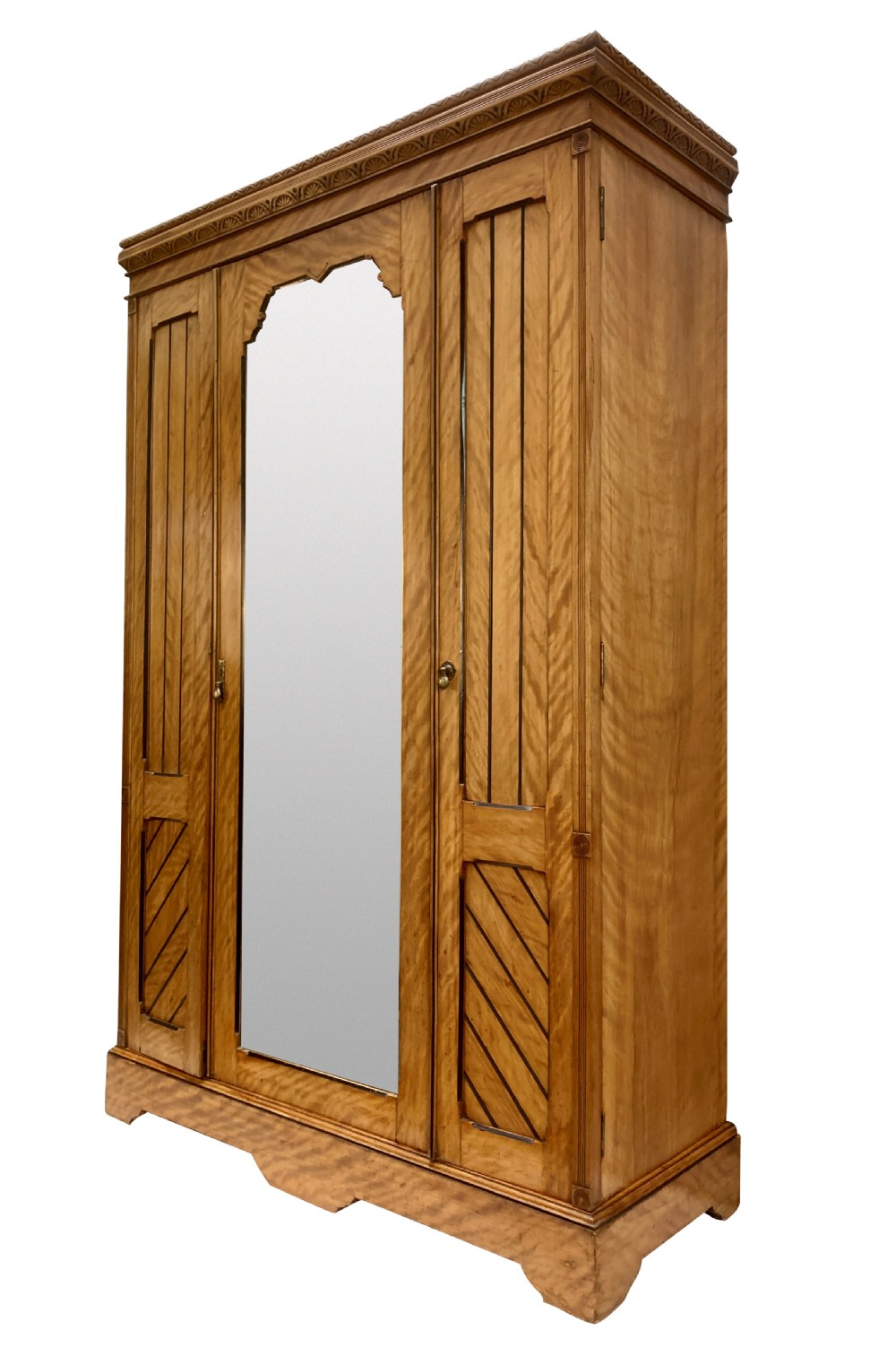 An Aesthetic Movement satin birch wardrobe featuring a central mirrored door flanked by geometric panelled side doors and a carved frieze. View II