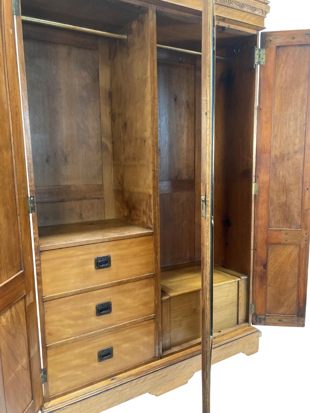 An Aesthetic Movement satin birch wardrobe featuring a central mirrored door flanked by geometric panelled side doors and a carved frieze. View VIII