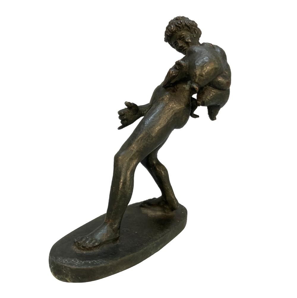 A dark patinated bronze statuette depicting the mythological figure Dionysus standing on an oval base. View IV
