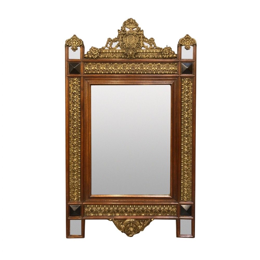 A 19th-century Flemish rectangular wall mirror featuring embossed brass panels, decorative cresting, and dark wooden moulding.