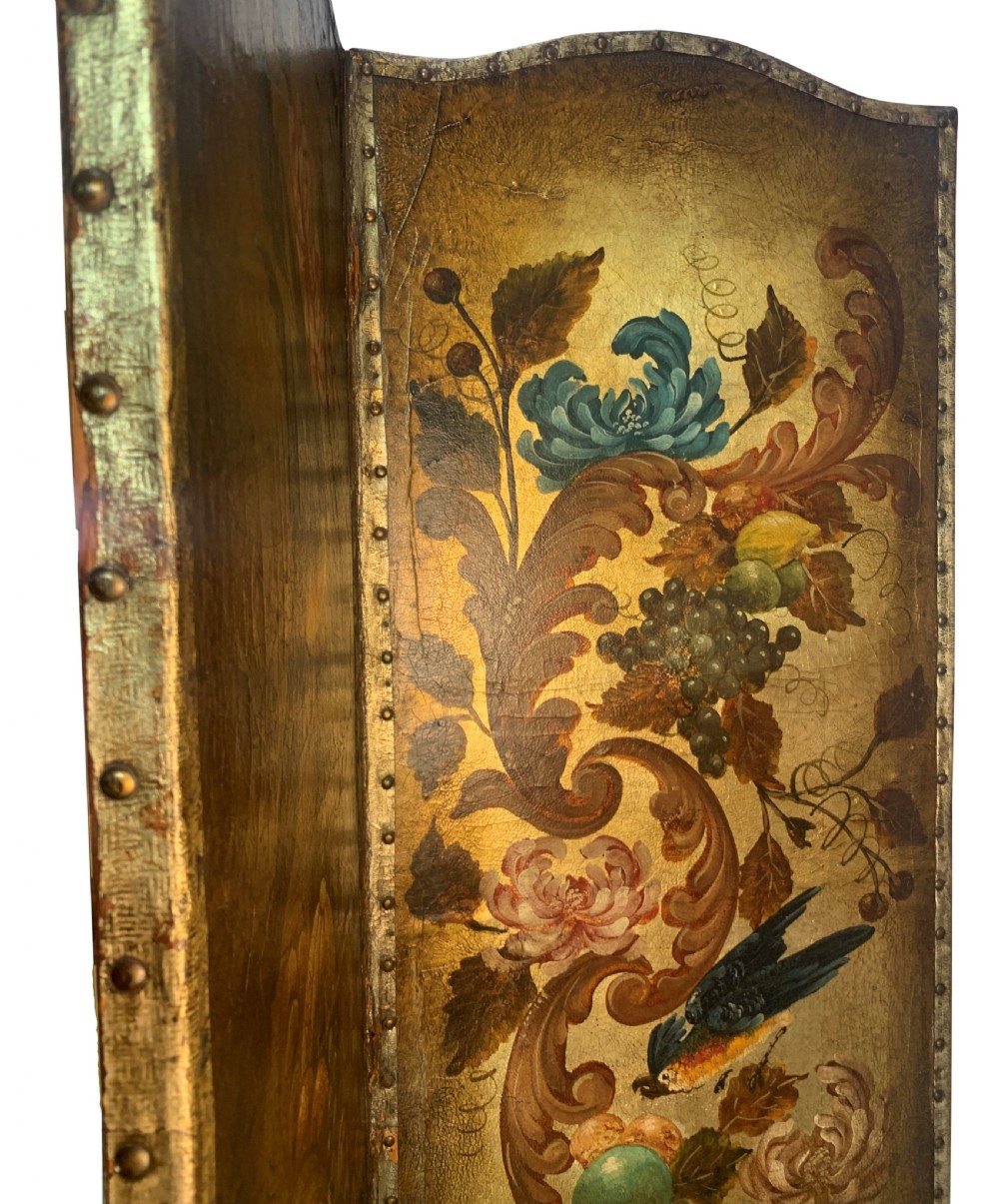An eighteenth-century four-panel folding screen featuring embossed and hand-painted gilt leather decorated with botanical scrollwork, birds, and fruit, bordered with brass studs. View VI