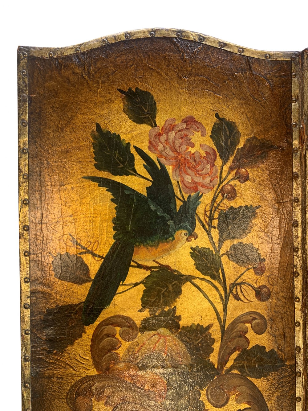 An eighteenth-century four-panel folding screen featuring embossed and hand-painted gilt leather decorated with botanical scrollwork, birds, and fruit, bordered with brass studs. View VII
