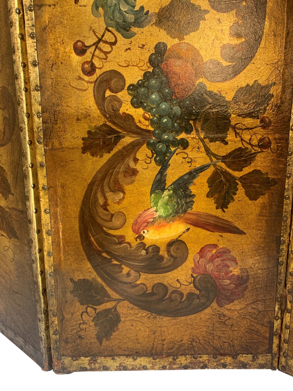 An eighteenth-century four-panel folding screen featuring embossed and hand-painted gilt leather decorated with botanical scrollwork, birds, and fruit, bordered with brass studs. View IX