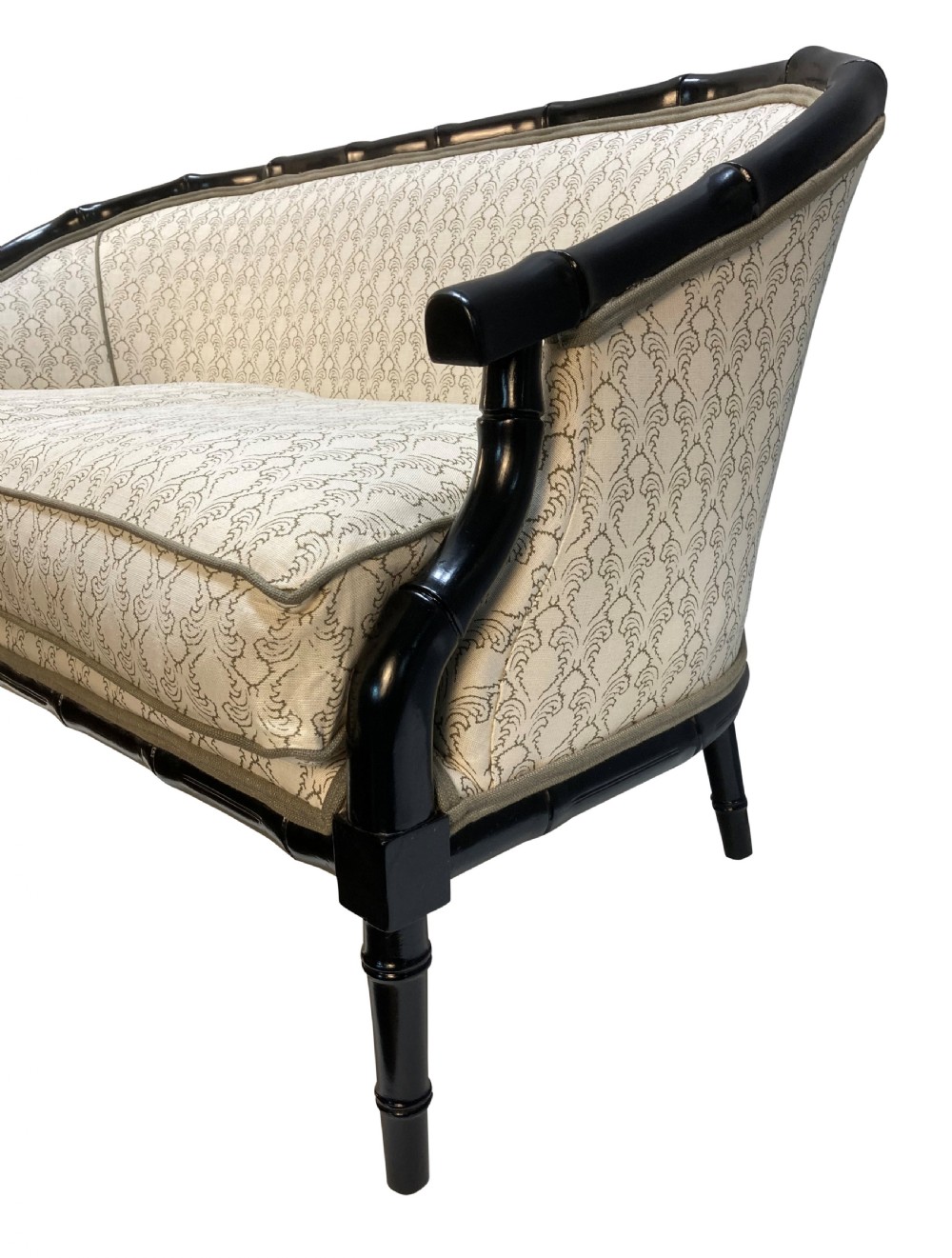 A 1930s French faux bamboo sofa featuring a black lacquered carved frame with a curved back and cream patterned upholstery. View III