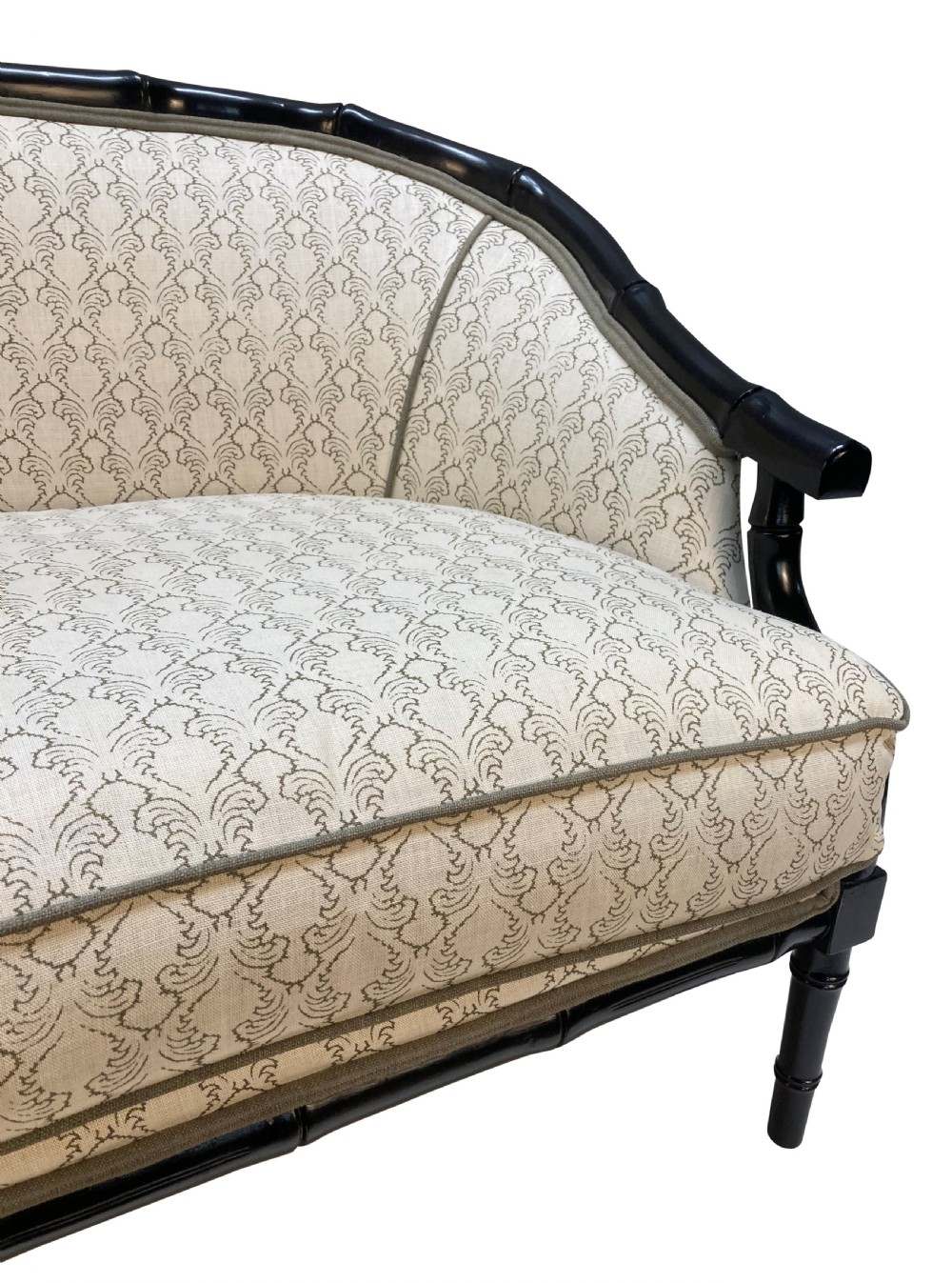 A 1930s French faux bamboo sofa featuring a black lacquered carved frame with a curved back and cream patterned upholstery. View IV