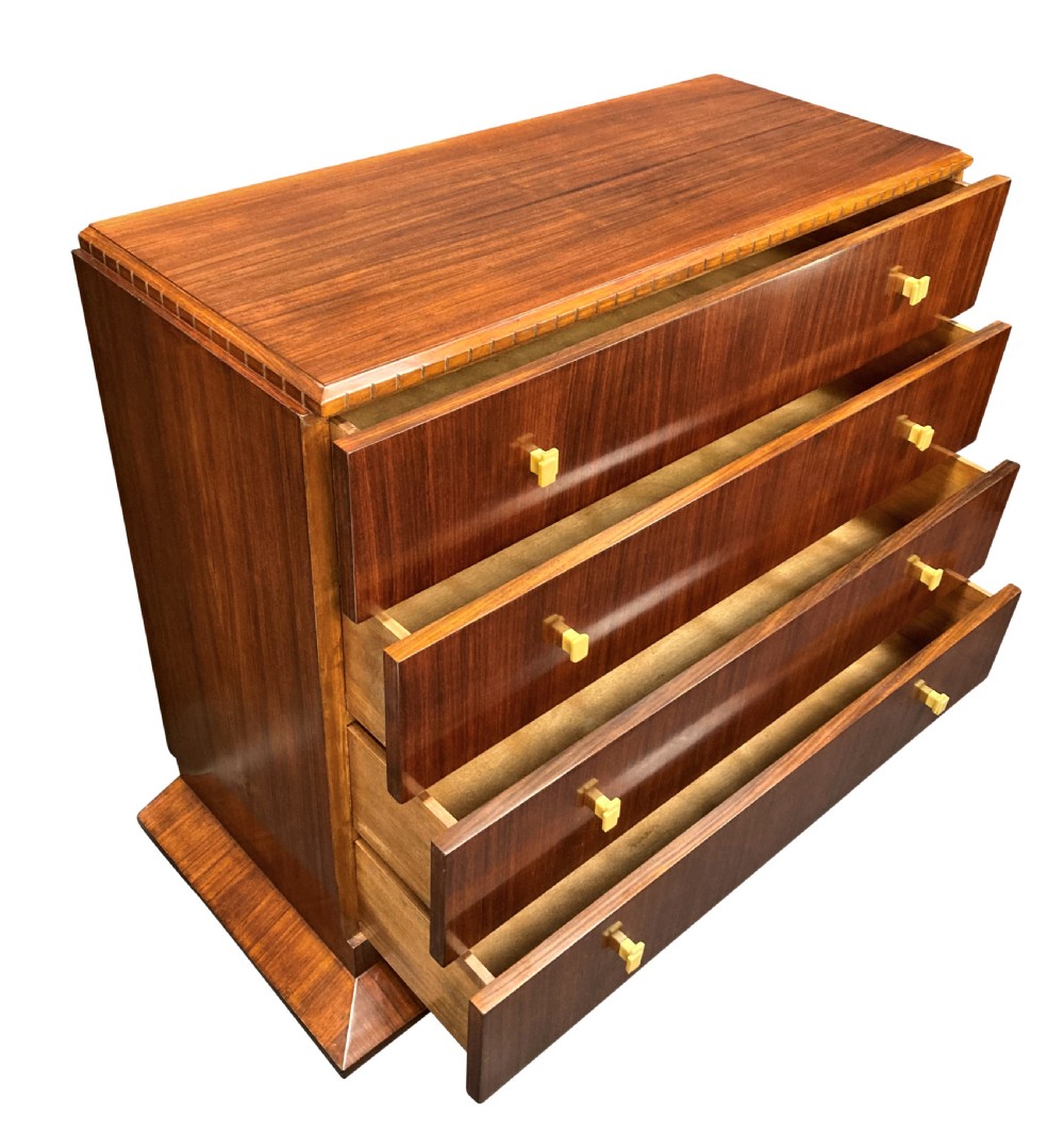An Art Deco dark wood commode featuring four stacked drawers with cream-coloured Bakelite handles resting on a stepped plinth base. View VIII