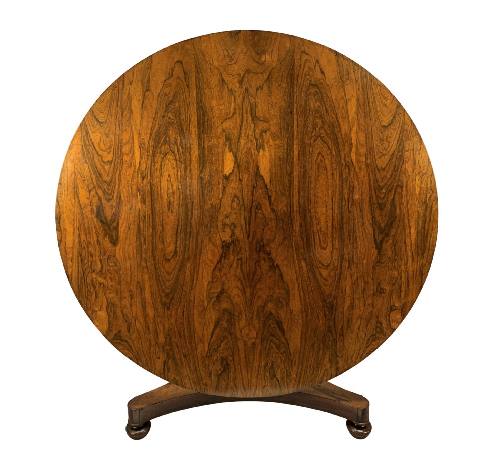 A circular William IV rosewood tilt-top centre table featuring a book-matched veneer top, turned column, and triform base on bun feet. View II