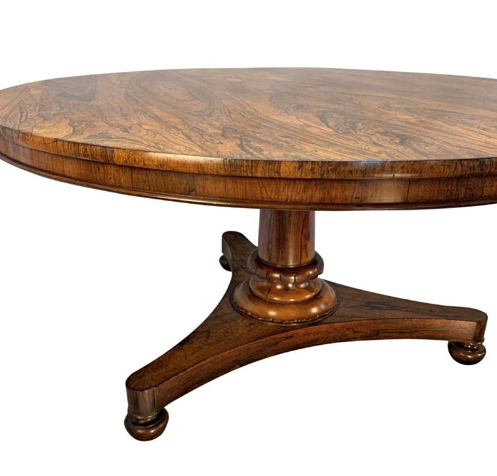 A circular William IV rosewood tilt-top centre table featuring a book-matched veneer top, turned column, and triform base on bun feet. View III