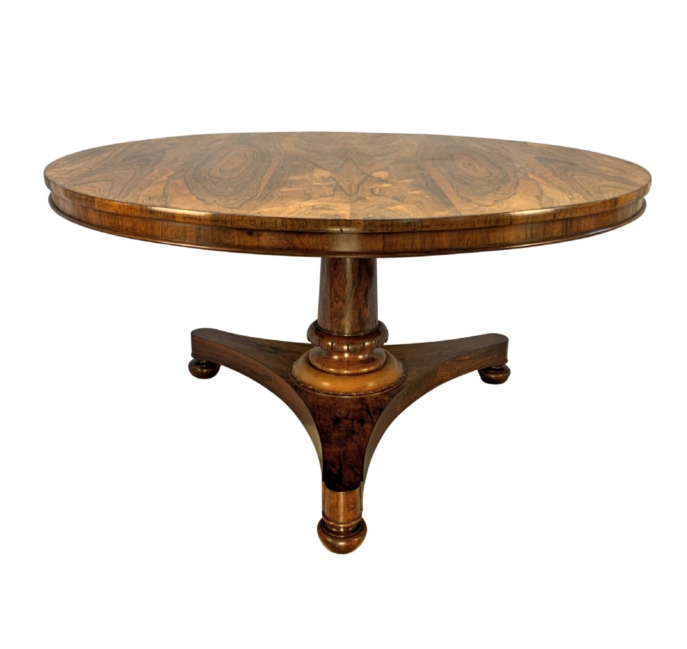 A circular William IV rosewood tilt-top centre table featuring a book-matched veneer top, turned column, and triform base on bun feet. View VII