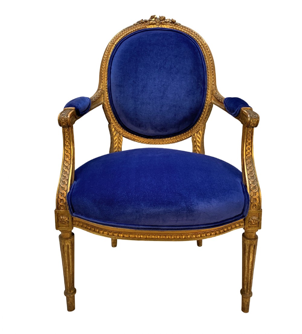 A set of four Louis XVI style armchairs featuring carved giltwood frames with oval medallion backs and royal blue velvet upholstery. View II