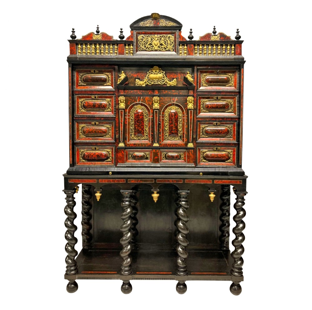 A 17th-century Flemish architectural cabinet on stand featuring red tortoiseshell veneered drawer fronts, gilt bronze mounts, and six ebonised barley-twist legs.