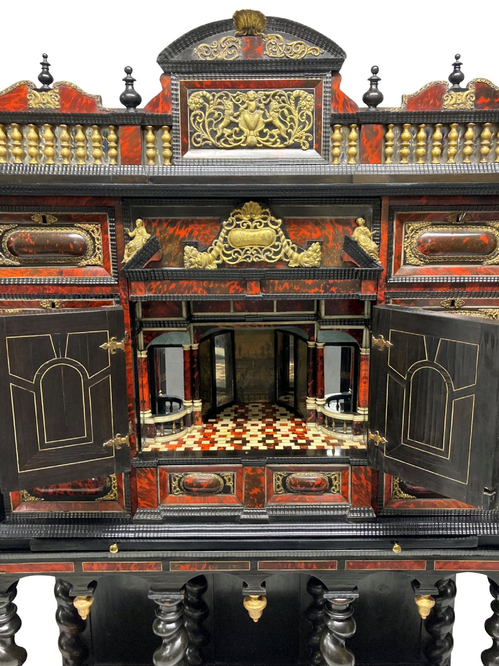 A 17th-century Flemish architectural cabinet on stand featuring red tortoiseshell veneered drawer fronts, gilt bronze mounts, and six ebonised barley-twist legs. View X
