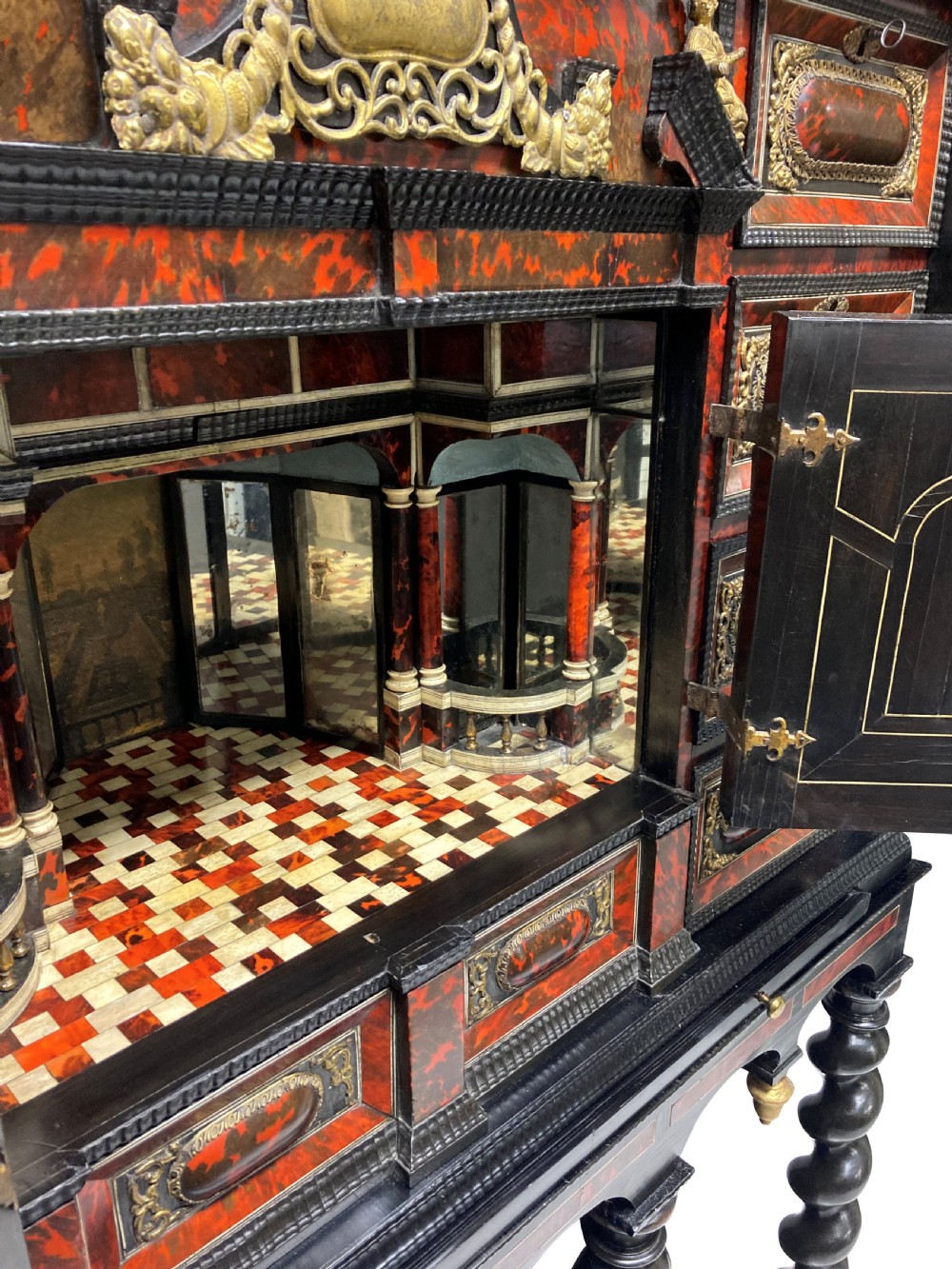 A 17th-century Flemish architectural cabinet on stand featuring red tortoiseshell veneered drawer fronts, gilt bronze mounts, and six ebonised barley-twist legs. View XII