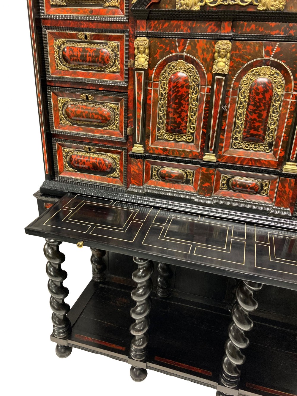 A 17th-century Flemish architectural cabinet on stand featuring red tortoiseshell veneered drawer fronts, gilt bronze mounts, and six ebonised barley-twist legs. View XV