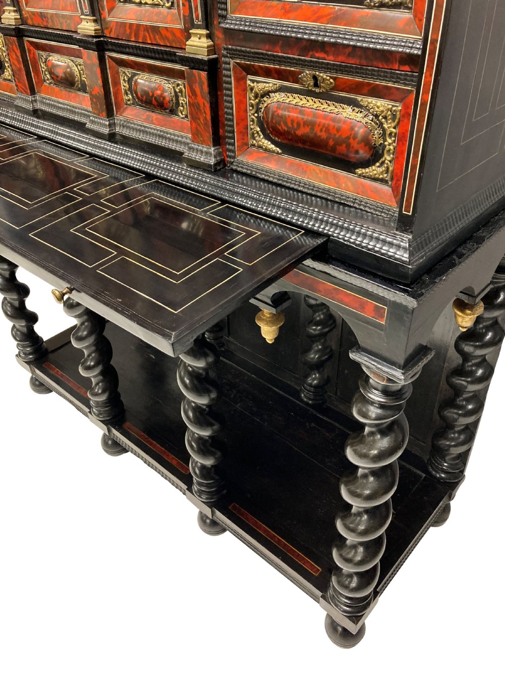 A 17th-century Flemish architectural cabinet on stand featuring red tortoiseshell veneered drawer fronts, gilt bronze mounts, and six ebonised barley-twist legs. View XVI
