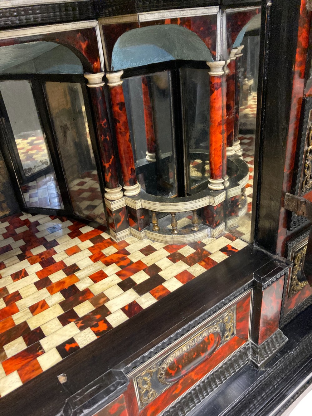 A 17th-century Flemish architectural cabinet on stand featuring red tortoiseshell veneered drawer fronts, gilt bronze mounts, and six ebonised barley-twist legs. View XVII