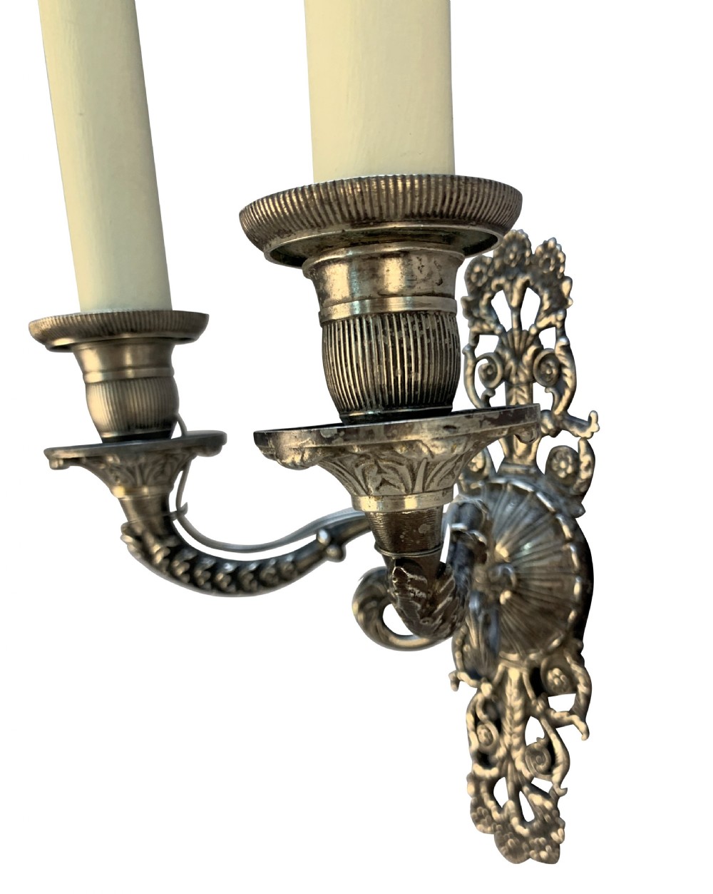 A pair of silver-plated French Empire style two-light wall sconces with ornate foliate backplates and cream candle sleeves. View IV