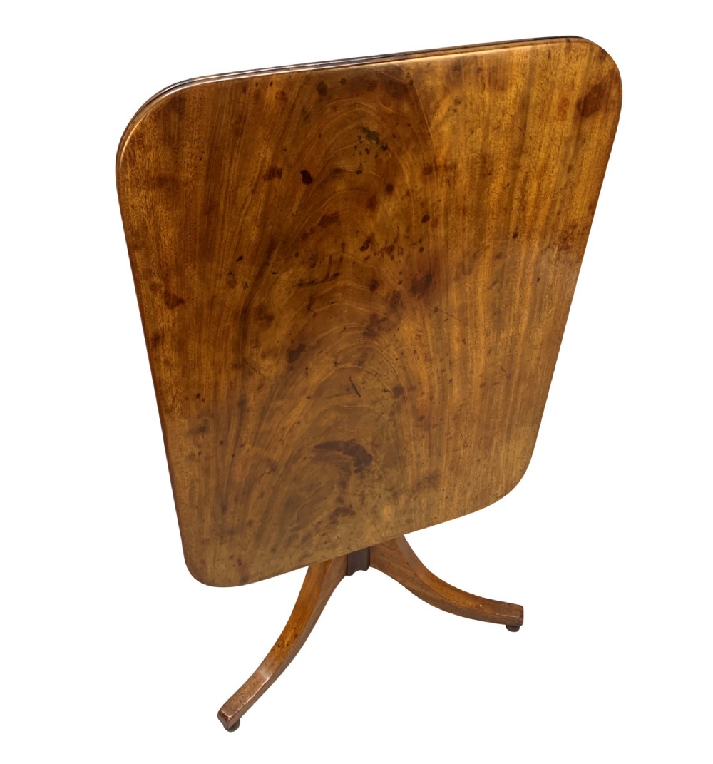 A George III mahogany side table featuring a rounded rectangular tilt-top on a turned pedestal with three splayed tripod legs. View II