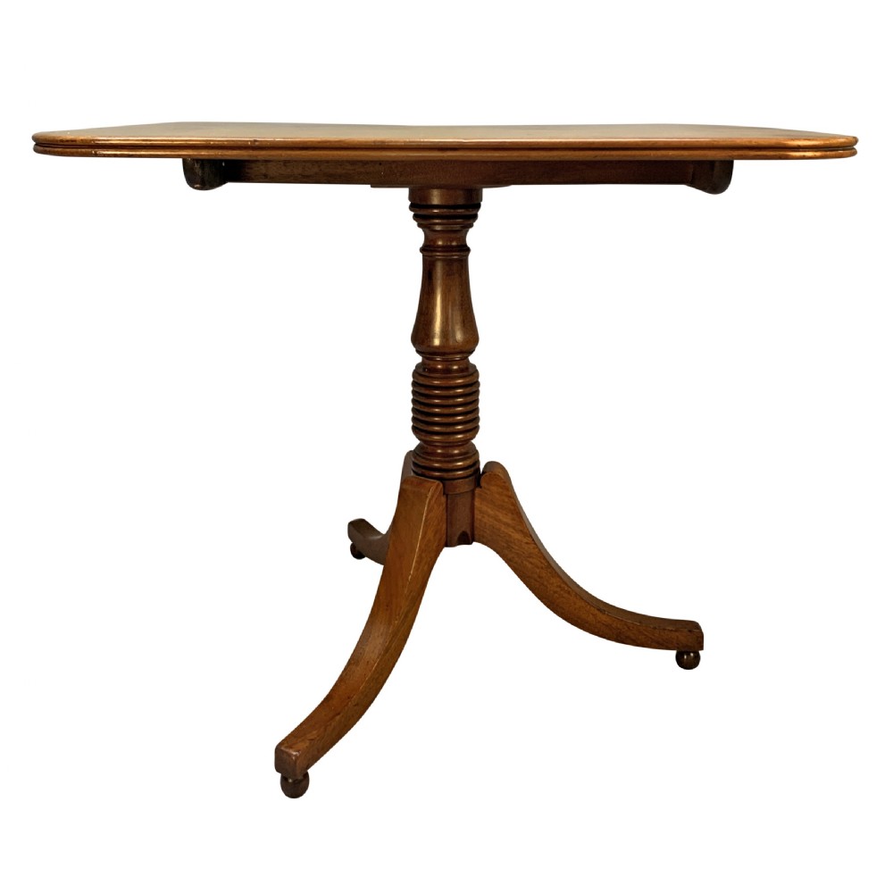 A George III mahogany side table featuring a rounded rectangular tilt-top on a turned pedestal with three splayed tripod legs. View V