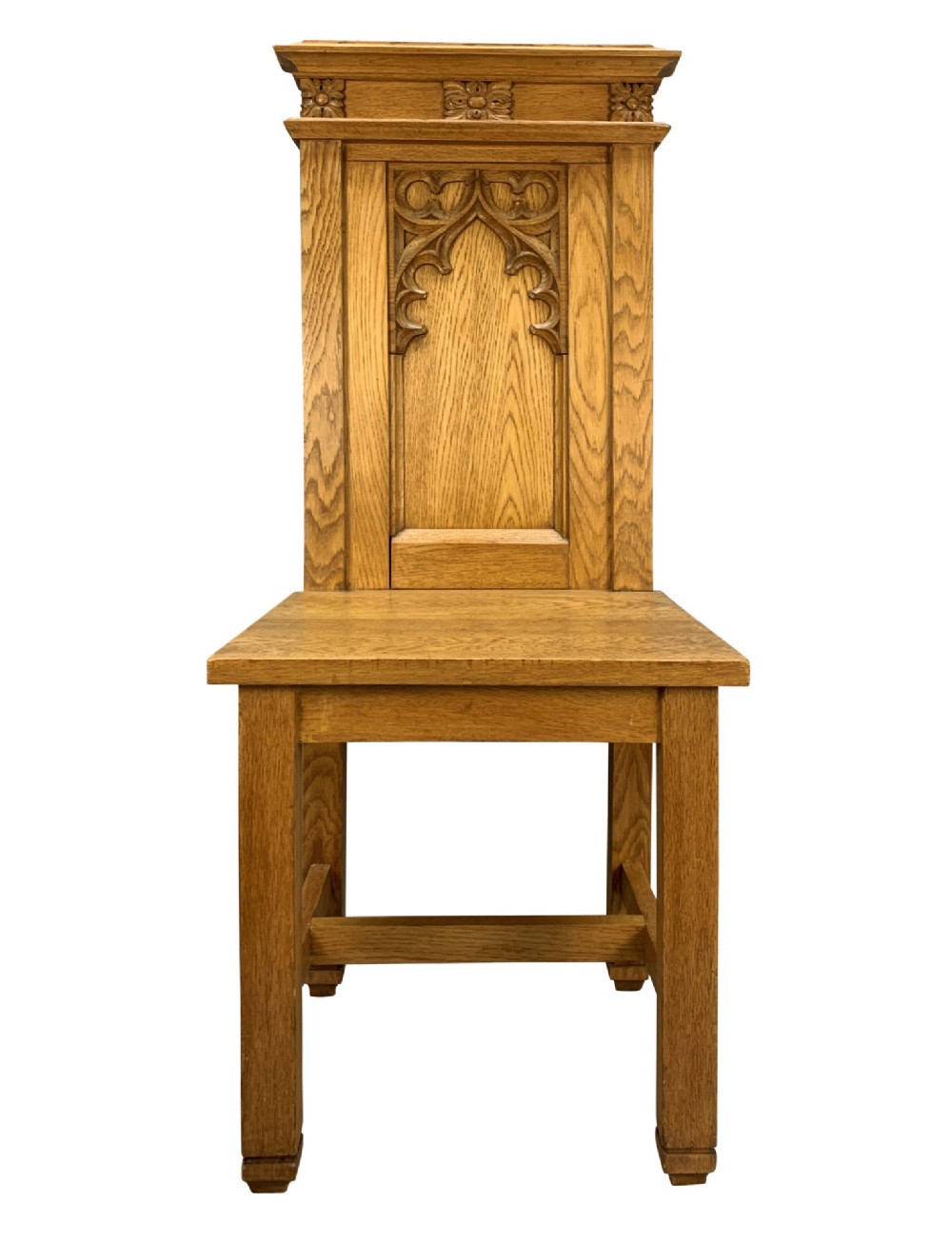 A set of four solid English oak hall chairs featuring carved Gothic arch panels on the backrests, flat solid seats, and straight legs with H-stretchers. View III