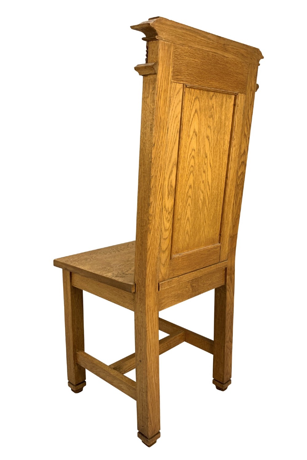 A set of four solid English oak hall chairs featuring carved Gothic arch panels on the backrests, flat solid seats, and straight legs with H-stretchers. View VI