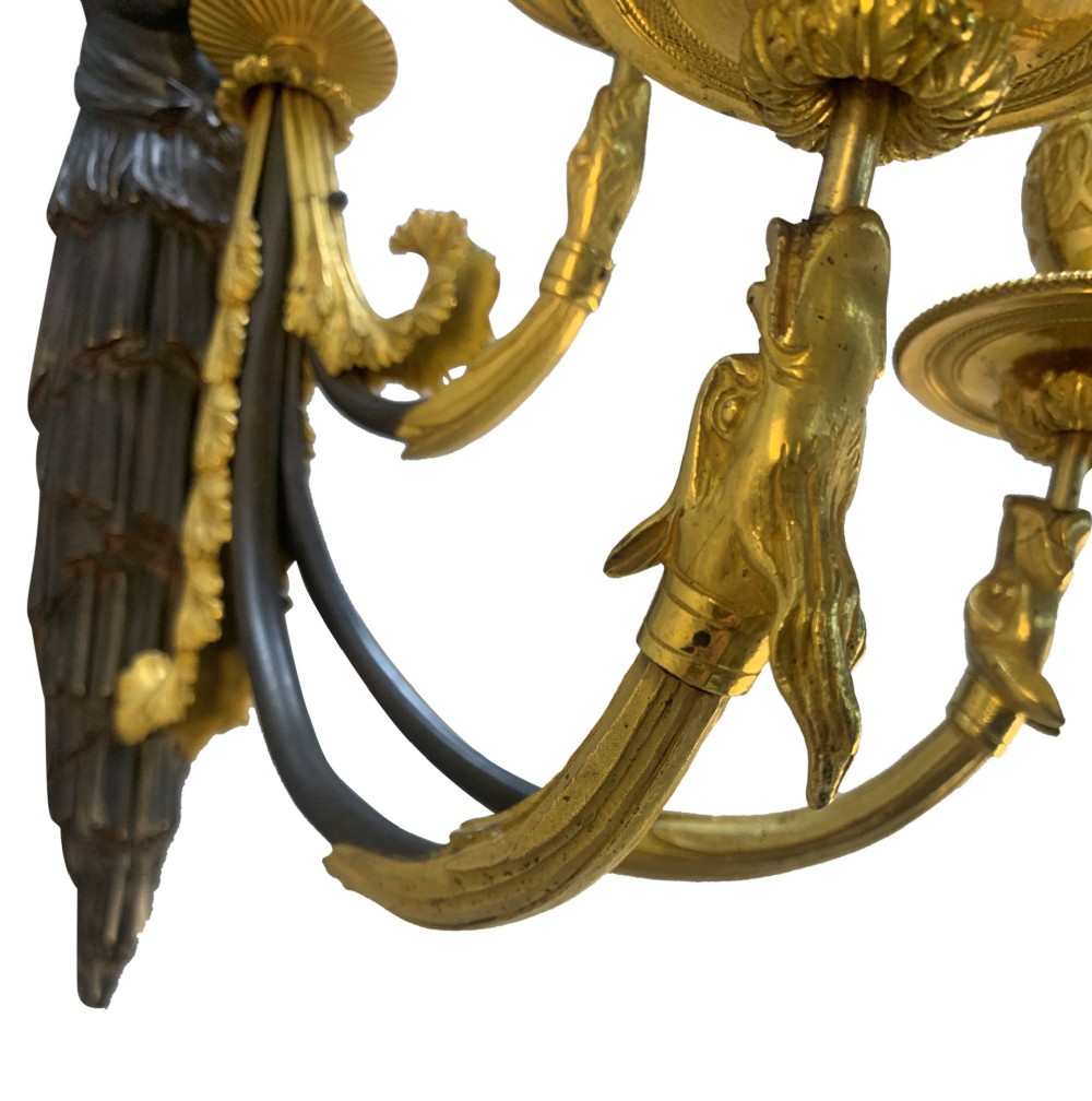 A pair of Neoclassical wall lights featuring dark patinated bronze female caryatid figures holding gilt bronze multi-arm candle holders with urn nozzles. View II