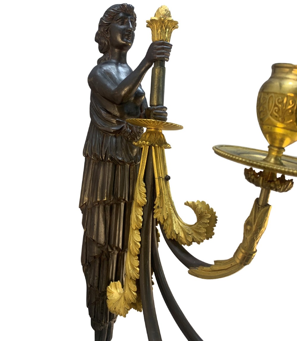A pair of Neoclassical wall lights featuring dark patinated bronze female caryatid figures holding gilt bronze multi-arm candle holders with urn nozzles. View III
