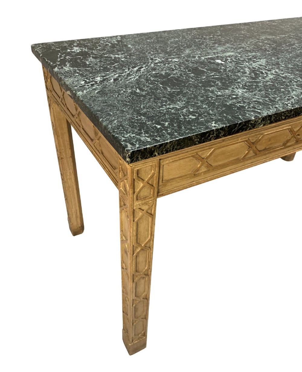 A pair of George III style natural pine console tables featuring carved geometric lattice friezes and dark green marble tops. View III