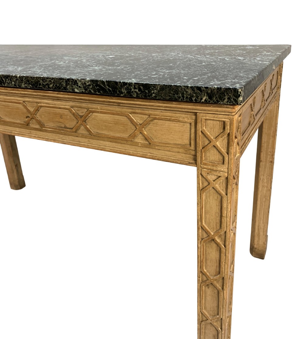 A pair of George III style natural pine console tables featuring carved geometric lattice friezes and dark green marble tops. View IV