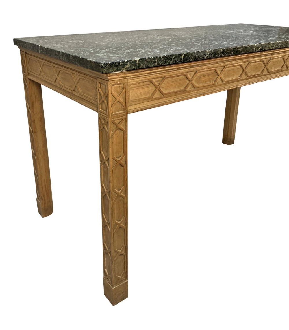 A pair of George III style natural pine console tables featuring carved geometric lattice friezes and dark green marble tops. View V
