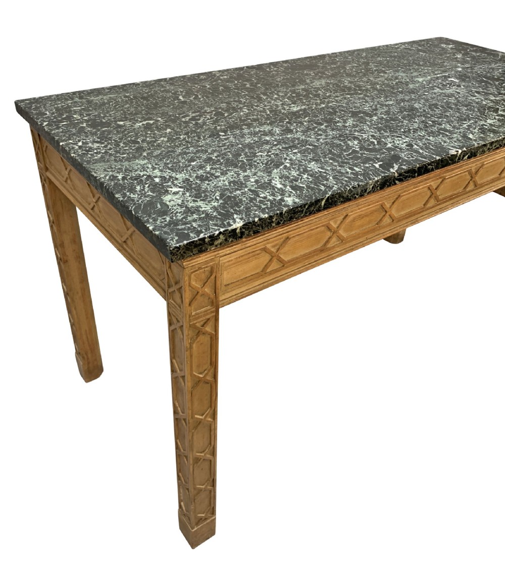 A pair of George III style natural pine console tables featuring carved geometric lattice friezes and dark green marble tops. View IX