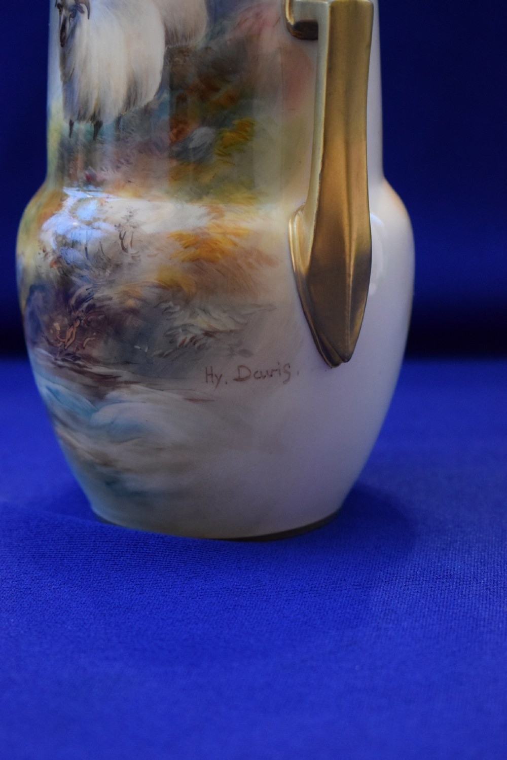 A tall, tapered antique Royal Worcester porcelain vase featuring a hand-painted scene of two sheep in a misty highland landscape with gilded angular side handles. View II
