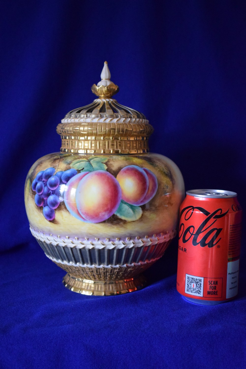 A Royal Worcester three-piece porcelain potpourri vase featuring hand-painted fruit artwork, gilded basketweave lower trim, and a reticulated gold cover. View V