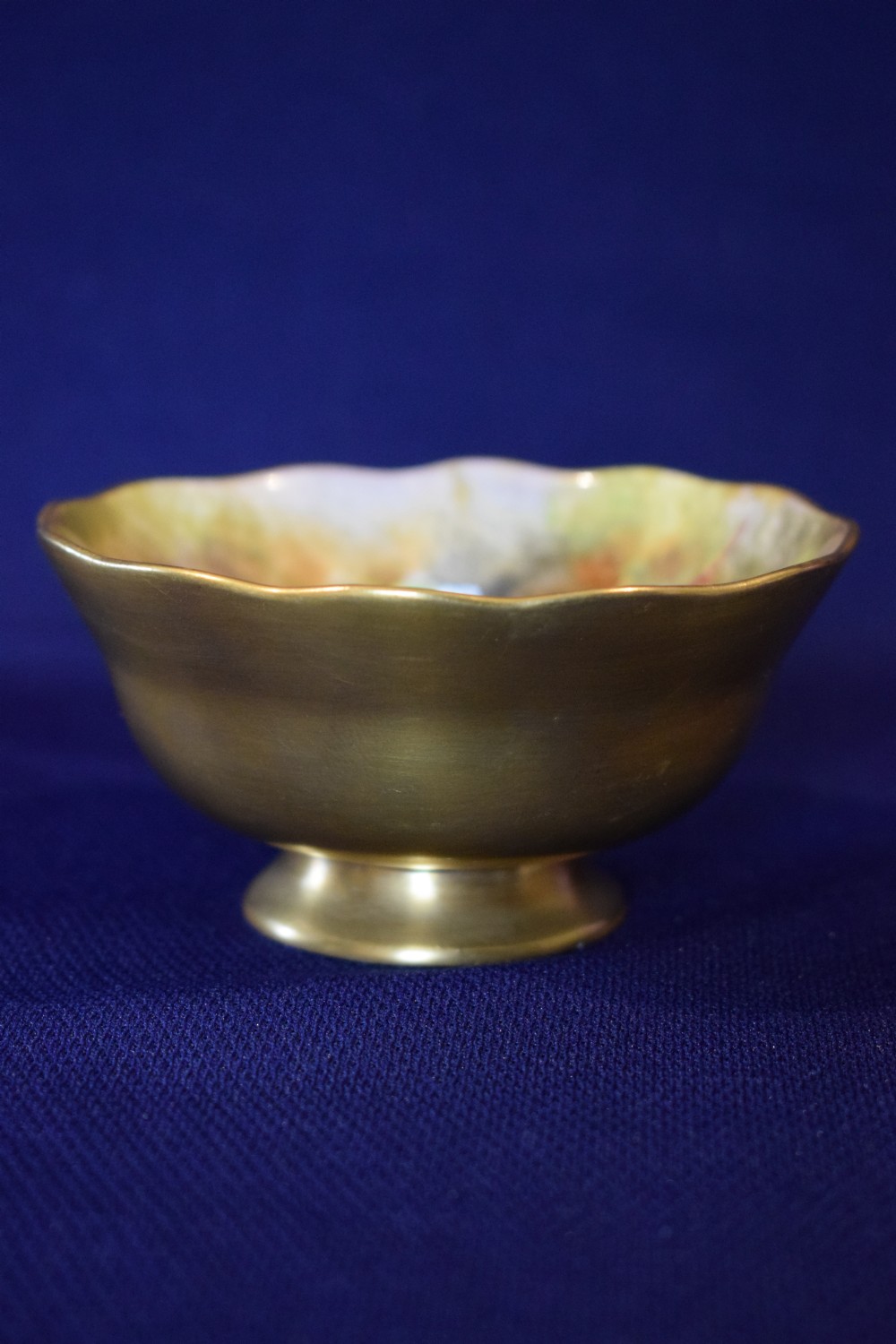 A small gilt porcelain sugar bowl with a scalloped edge featuring a hand-painted fruit motif on the interior surface. View II