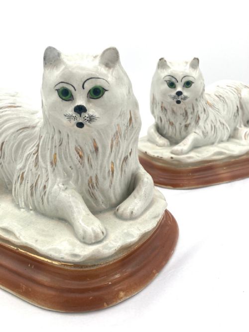 an unusual pair of late 19th century recumbent staffordshire cats - CATEGORY: ANTIQUE CERAMICS - DATED 19TH CENTURY