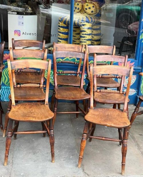 A set of ten early Victorian wooden dining chairs with turned legs, curved top rails, and solid timber seats, featuring two armchairs and eight side chairs. View III