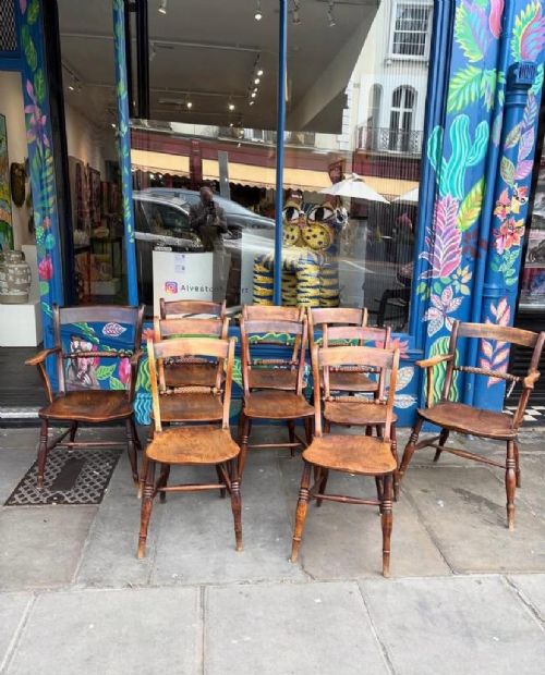 A set of ten early Victorian wooden dining chairs with turned legs, curved top rails, and solid timber seats, featuring two armchairs and eight side chairs. View IV