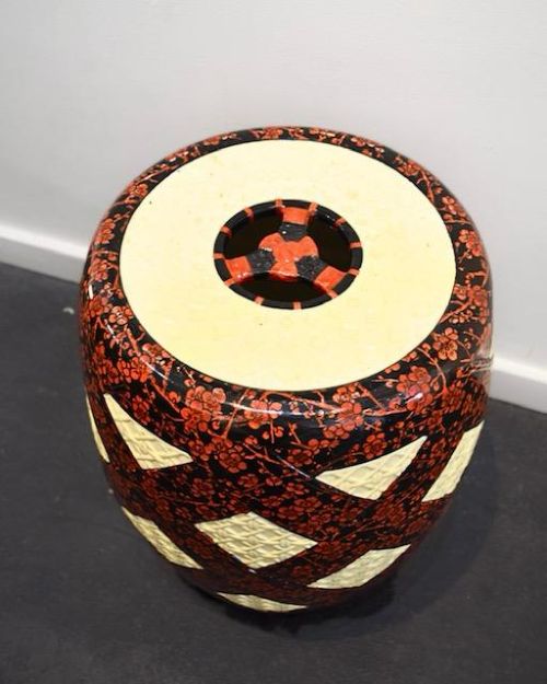 A barrel-shaped Victorian ceramic garden seat by Minton featuring cream lattice-patterned diamond panels against a dark background decorated with red floral blossom motifs. View III