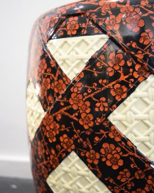A barrel-shaped Victorian ceramic garden seat by Minton featuring cream lattice-patterned diamond panels against a dark background decorated with red floral blossom motifs. View IV