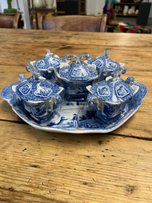 fig 1. A nineteenth-century blue and white English transferware custard set featuring lidded pots arranged on a matching shaped tray.