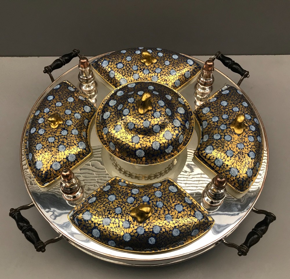 An early 19th-century Coalport porcelain supper set featuring cobalt blue and gold floral pattern covered dishes and condiment shakers set on a revolving silver-plated tray with dark wood handles. View II