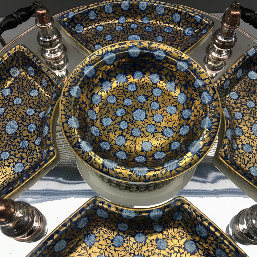 An early 19th-century Coalport porcelain supper set featuring cobalt blue and gold floral pattern covered dishes and condiment shakers set on a revolving silver-plated tray with dark wood handles. View V