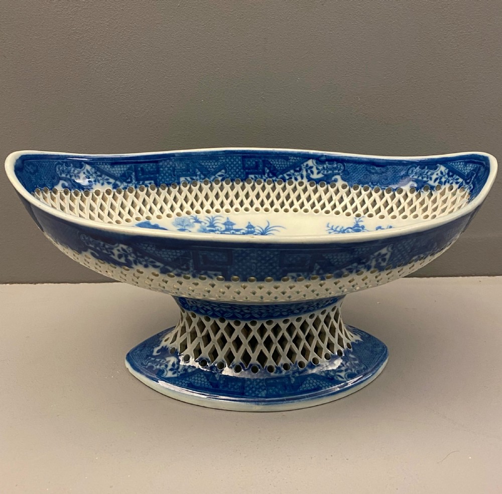 An eighteenth-century oval blue and white pearlware comport featuring reticulated pierced lattice work around the bowl and pedestal base, decorated with chinoiserie transfer patterns.