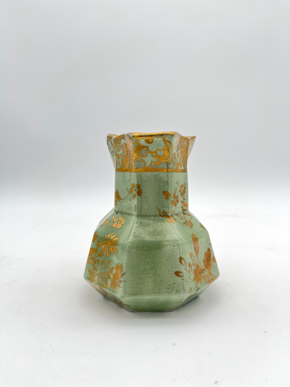 A set of three graduated octagonal sage green ironstone jugs decorated with gilded floral motifs and ornate moulded scroll handles. View XI