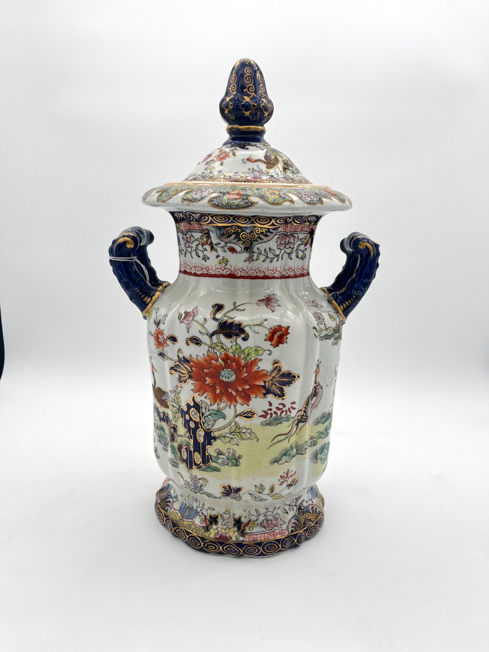A pair of white and cobalt blue ceramic ironstone essence jars adorned with floral motifs, scroll handles, and fitted lids. View II