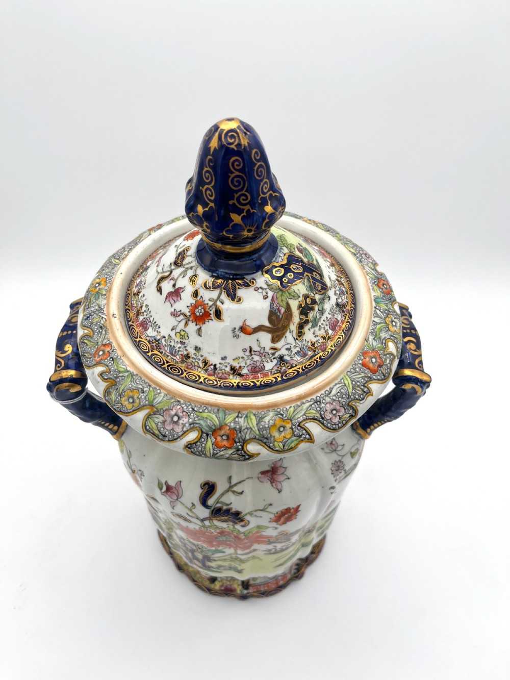 A pair of white and cobalt blue ceramic ironstone essence jars adorned with floral motifs, scroll handles, and fitted lids. View III