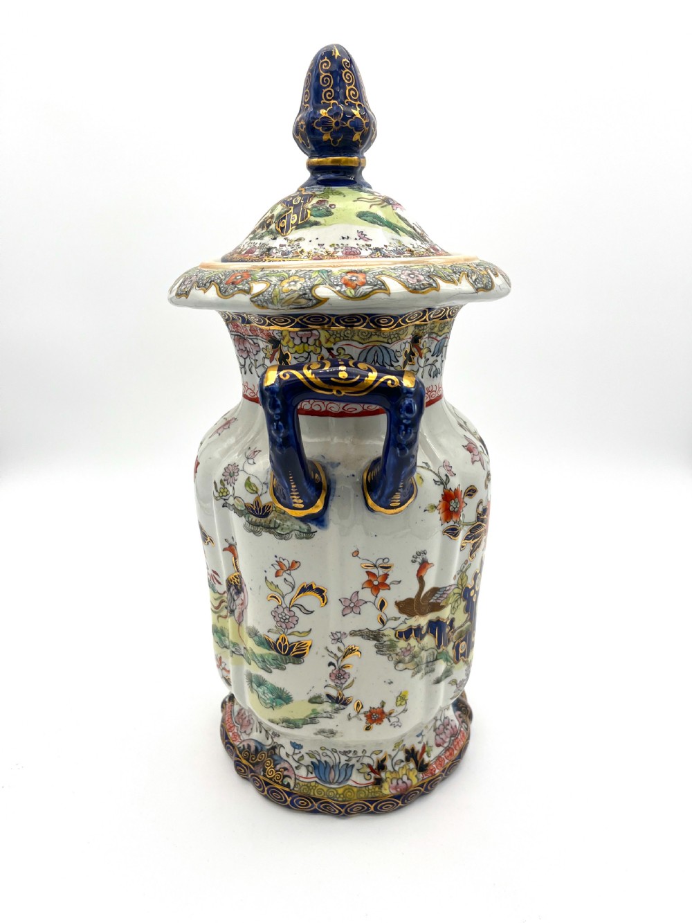 A pair of white and cobalt blue ceramic ironstone essence jars adorned with floral motifs, scroll handles, and fitted lids. View VI
