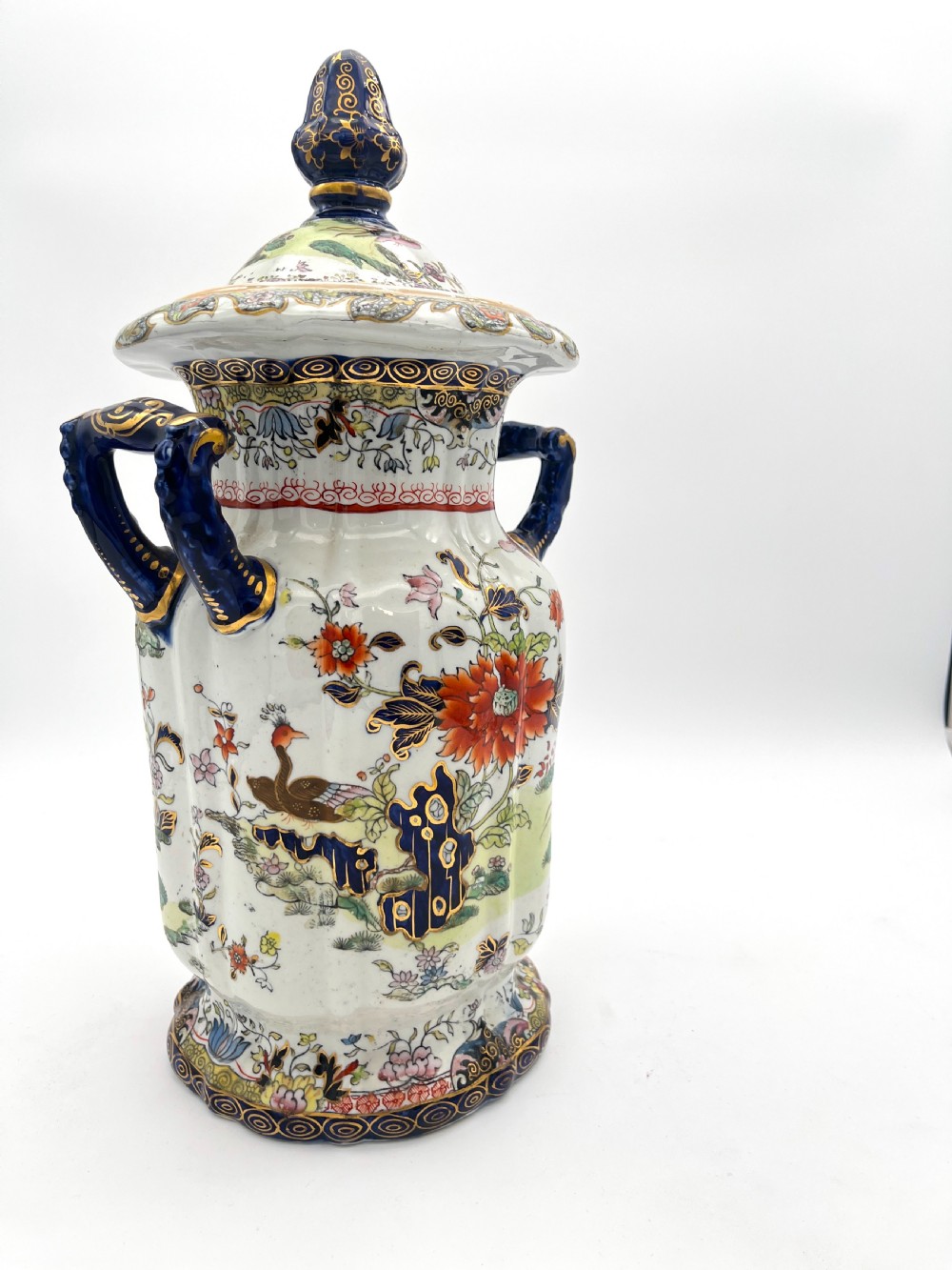 A pair of white and cobalt blue ceramic ironstone essence jars adorned with floral motifs, scroll handles, and fitted lids. View VIII