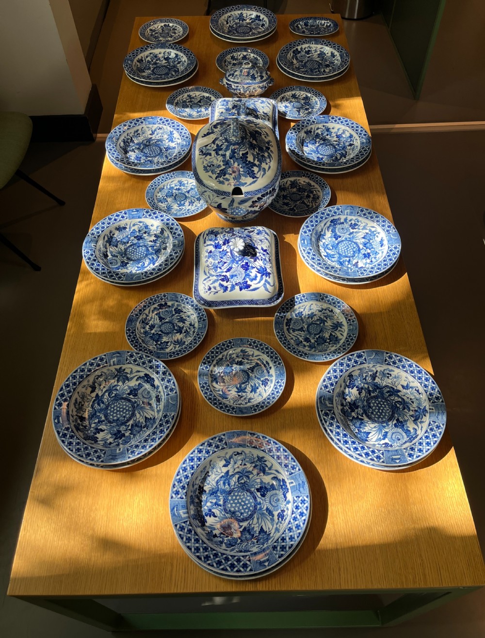 An extensive blue and white transfer-printed Wedgwood earthenware dinner service in the Hibiscus pattern featuring plates, serving dishes, and a covered tureen.